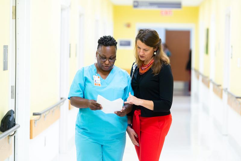 Two female health workers talking in hallway